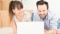 Un jeune couple sourit en planifiant son projet de chauffage résidentiel pas à pas sur un ordinateur portable.