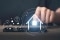 L'image montre une personne qui touche l'écran d'un smartphone et des symboles lumineux représentant un système de gestion de l'énergie domestique.