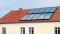 La photo montre des panneaux solaires sur le toit comme appoint au chauffage.