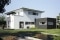 L'illustration représente une maison neuve moderne et lumineuse avec une véranda.